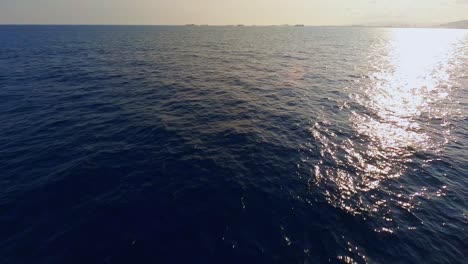 FPV-aerial-flying-down-toward-a-sailing-yacht-and-across-the-bright,-blue-water-of-the-Mediterranean-Sea