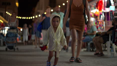 Young-hispanic-latin-toddler-baby-boy-walking-through-the-streets-of-downtown-isla-mujeres-exploring-the-place-on-warm-evening