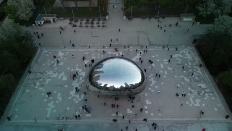 Aerial-descent-pan-of-tourists-at-Chicago-Cloud-Gate-Sculpture