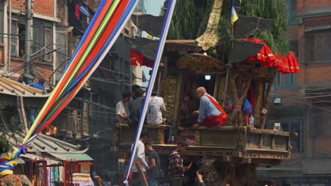 Nepalese-people-riding-a-big-colorful-traditional-wooden-wagon,-in-the-streets-of-Kathmandu,-Nepal
