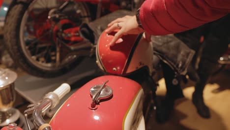 Junger-Mann-Schaut-Und-Berührt-Vintage-Helm-Und-Motorrad-Im-Motala-Motormuseum-In-Schweden