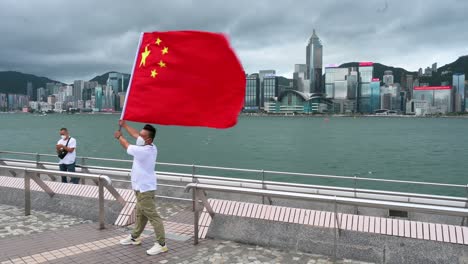 Ein-Mann-Posiert-Mit-Der-Chinesischen-Flagge-Am-Hafen-Von-Victoria-Anlässlich-Des-25.-Jahrestages-Der-Gründung-Der-Sonderverwaltungszone-Hongkong-Der-Volksrepublik-China