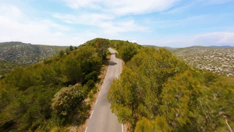 Cinematic-FPV-aerial-tracking-a-car-driving-along-a-scenic-mountain-road