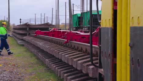 crane-unloads-new-train-track,-railroad-worker-assist,-wide-shot