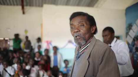 Un-Anciano-Africano-Con-Traje-Se-Dirige-A-Los-Estudiantes-De-La-Escuela-De-Kalabo,-Zambia