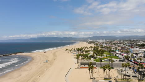 Ascending-aerial-view-of-people-at-the-Venice-Beach,-in-sunny-Los-Angeles,-USA