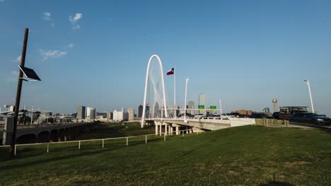 Timelapse-or-motionlapse-of-the-Margaret-Hunt-Hill-Bridge-located-in-dallas,-texas,-USA,-while-vehicles-and-people-cross-the-bridge,-with-the-background-of-the-dallas-skyscrapers
