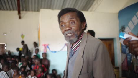 Un-Anciano-Africano-Vestido-Con-Traje-Comparte-Un-Mensaje-Inspirador-A-Los-Estudiantes-De-La-Escuela