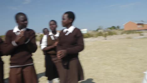 Panorámica-De-Estudiantes-En-Kalabo,-Zambia,-Bailando-Afuera,-Tocando-Tambores-Y-Cantando.