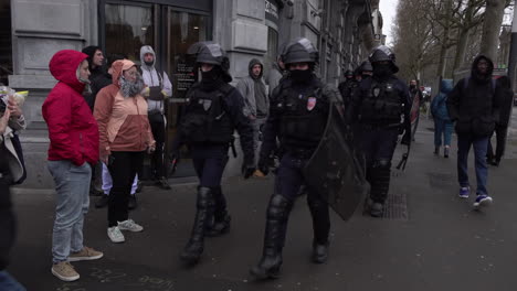 Eine-Einheit-Maskierter-Bereitschaftspolizisten-Mit-Helmen-Und-Schutzschilden-Geht-Während-Des-Landesweiten-Streiks-Und-Der-Proteste-Gegen-Eine-Anhebung-Des-Rentenalters-Eine-Straße-Entlang