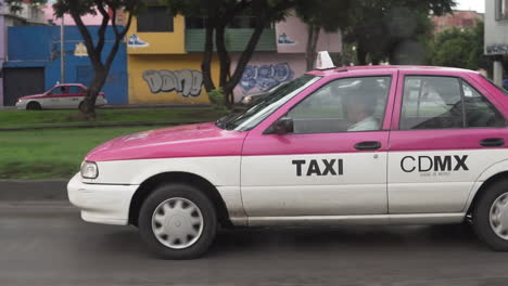 Taxi-Rosa-Y-Blanco-Conduciendo-Por-Las-Calles-De-La-Ciudad-De-México-DF