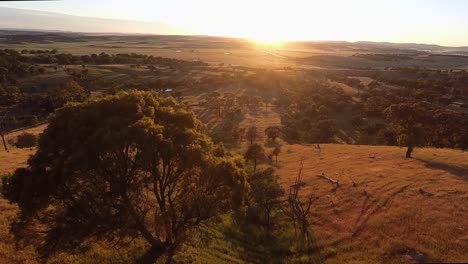 Fliegen-Sie-über-Die-Australische-Landschaft,-Während-Im-Hintergrund-Die-Sonne-Aufgeht