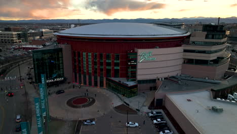 Vivid-sunset-sky-over-iconic-Ball-Arena-in-Denver-Colorado,-aerial-view