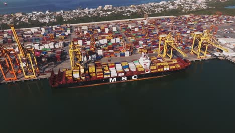 Container-Ship-Loading-And-Unloading-In-Seaport-Of-Manzanillo-In-Colima,-Mexico---aerial-drone-shot