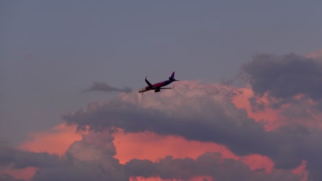 A-handheld-shot-captures-a-Wizzair-plane-landing-in-Split,-Croatia,-during-a-picturesque-sunset-with-palm-trees-in-the-foreground