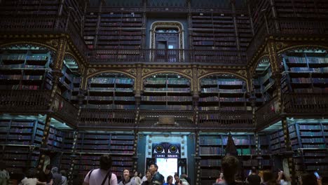 Tilt-down-of-the-library-of-the-Real-Gabinete-Português-de-Lectura-visited-by-a-group-of-tourists,-excellent-old-architecture-in-Rio-de-Janeiro,-Brazil