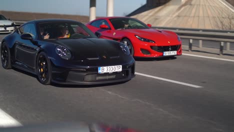 Black-Porsche-GT-racing-red-Ferrari-on-high-way-Slow-motion
