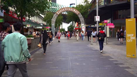 Point-of-view,-walk-through-shot-capturing-bustling-downtown-Queen-Street-Mall,-iconic-pedestrian-shopping-precinct-in-Brisbane-city-CBD,-central-business-district,-Queensland,-Australia