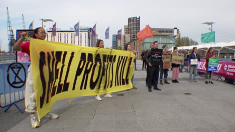 Climate-Change-activists-hold-a-yellow-banner-that-reads-“Shell-Profits-Kill”-next-to-other-protestors-holding-placards-outside-the-Shell-Annual-General-Meeting-at-the-Excel-Exhibition-Centre