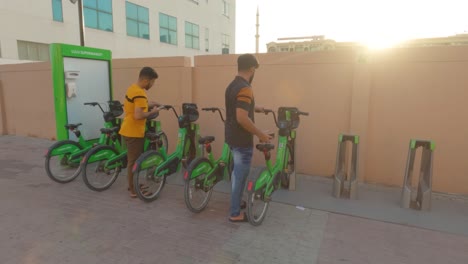 Erleben-Sie-Die-Bequemlichkeit-Und-Freiheit-Zweier-Männer,-Die-In-Dubai-Careem-Fahrräder-Aufschließen