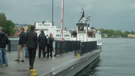 Ferry-De-Pasajeros-Llegando-Al-Muelle-De-Estocolmo,-Gente-Esperando-El-Ferry