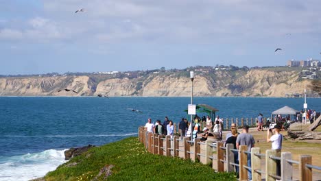 People-walking-in-scenic-La-Jolla-Park-in-San-Diego,-California-with-water-view