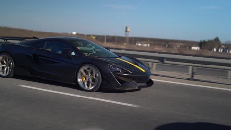 man-in-a-McLaren-sports-car-driving-a-on-a-highway---slow-motion