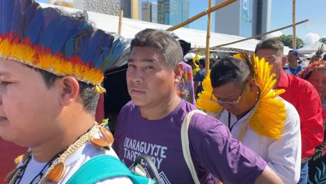 Indigene-Männer-Und-Frauen-Aus-Amazonas-Tragen-Traditionelle-Federhüte-Auf-Einem-Marktplatz-In-Brasilien