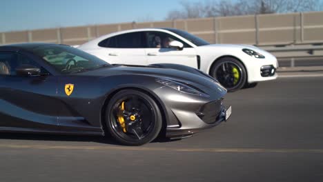 Ferrari-Negro-Compitiendo-Con-Un-Porsche-En-Una-Carretera