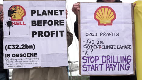 Aktivisten-Des-Klimawandels-Halten-Vor-Der-Jahreshauptversammlung-Von-Shell-Im-Excel-Exhibition-Centre-Plakate-Mit-Der-Aufschrift-„Planet-Vor-Profit“-Und-„Stoppt-Das-Bohren,-Fängt-An-Zu-Zahlen“.