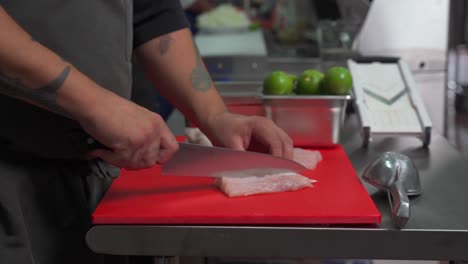 Latin-Mexican-chef-filleting-cleaning-Bass-fresh-fish-for-ceviche-at-latin-restaurant-kitchen