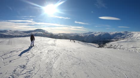 Tallest-top-of-Myrkdalen-ski-resort---Sunny-day-static-clip-with-skiers-going-downhill-and-beautiful-mountain-scenery-in-background