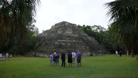Tourists-visiting-Chacchoben,-Temple-24-and-Plaza-B,-Mayan-archeological-site,-Quintana-Roo,-Mexico