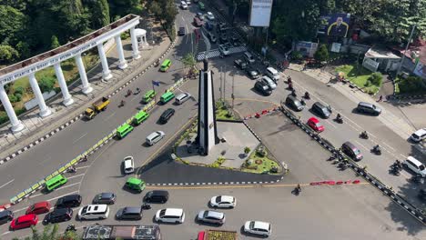 Traffic-jam-at-Tugu-Kujang-Monument-at-the-heart-of-Bogor-City,-cars-passing-roundabout