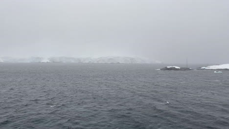Panning-view-onboard-expedition-ship-MS-EXPEDITION-at-Antarctic-Peninsula's-Melchior-Islands-during-snow-storm