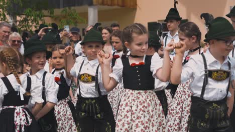 Children-dancing-in-traditional-Bavarian-clothes,-Lederhose-and-Dirndl-at-Maibaumaufstellen