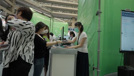 Lady-receiving-a-brochure-in-a-tech-expo-booth