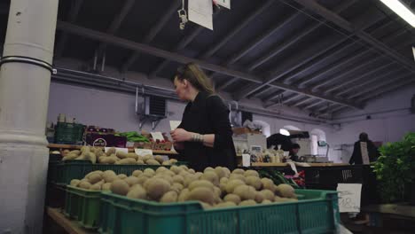 Eine-Frau-Wählt-Aus-Einer-Auswahl-Von-Obst--Und-Gemüseverkäufern-Auf-Einem-Lokalen-Markt