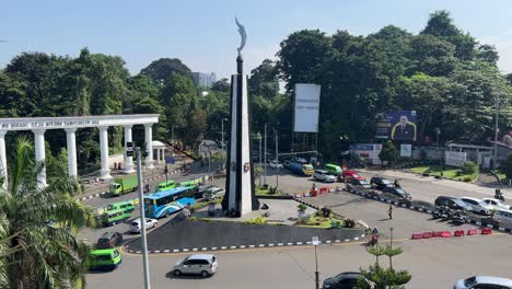 The-car-goes-around-the-Kujang-Monument,-busy-street