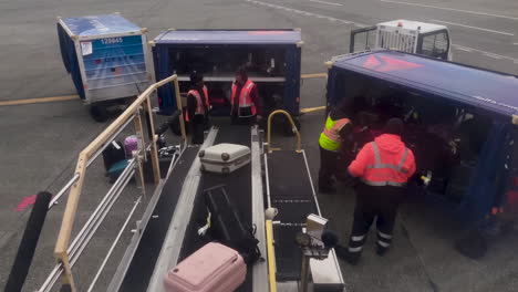 POV-From-Window-Seat-Of-Baggage-Handlers-Unloading-Bags-From-A-Plane