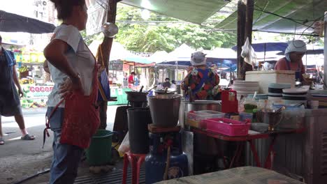 Disparo-En-El-Patio-De-Comidas-Dentro-Del-Famoso-Mercado-Chatuchak-En-Bangkok-Con-Gente-Tailandesa-Cocinando,-Tailandia