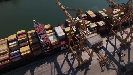 Cranes-And-Cargo-Ship-At-Port-Of-Manzanillo-In-Colima,-Mexico---aerial-top
