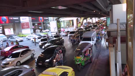 Toma-De-Atasco-Durante-El-Día-Debajo-De-Un-Puente-En-Bangkok-Con-Autos-Y-Tuktuk,-Tailandia.