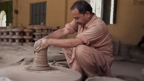 Artisan-shaping-clay-on-a-potter's-wheel,-crafting-beautiful-pottery