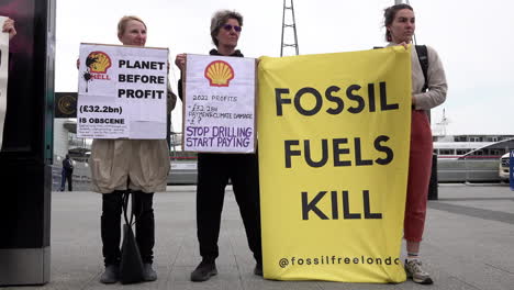 Climate-Change-activists-hold-placards-that-read,-“Planet-Before-Profit”-and-“Stop-Drilling-Start-Paying”-and-a-banner-that-reads,-“Fossil-Fuels-Kill”-outside-the-Shell-Annual-General-Meeting