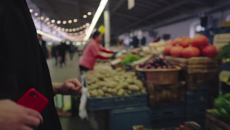Una-Mujer-Mira-Un-Pepino-En-Un-Mercado-Local-De-Frutas-Y-Verduras.