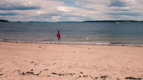 Frauen-Spielen-Mit-Golden-Retriever-Hund-Am-East-End-Beach-In-Portland,-Maine