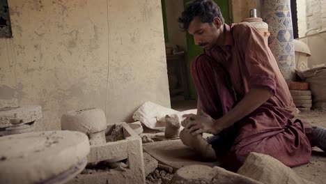 A-man-working-with-clay-through-kneading-for-pottery