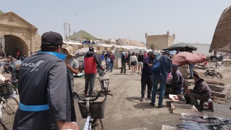 Tourists-and-locals-walking-and-shopping-at-Essaouira-Harbor,-Morocco