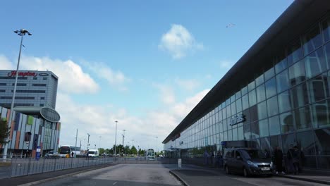 Taxi-departing-outside-front-entrance-of-John-Lennon-airport-international-terminal,-Liverpool,-England